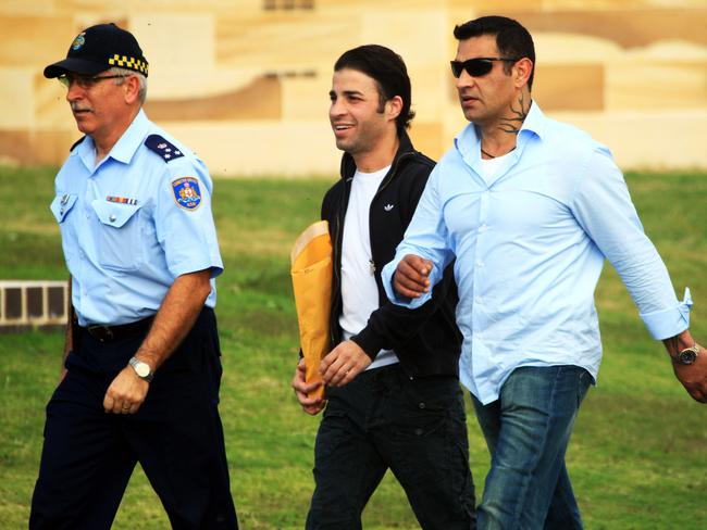 Fadi (C) and Sam Ibrahim (R) being escorted to the gate by a guard at the Long Bay Correctional Complex in southern Sydney.