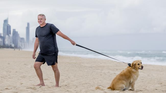 Mike Cook with his Golden Retriever Elsie, 6. Elsie has gone viral with her lazy antics on her morning walk. Picture: Jerad Williams