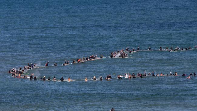 Mourners form a ring in the ocean. Picture: Brett Hartwig