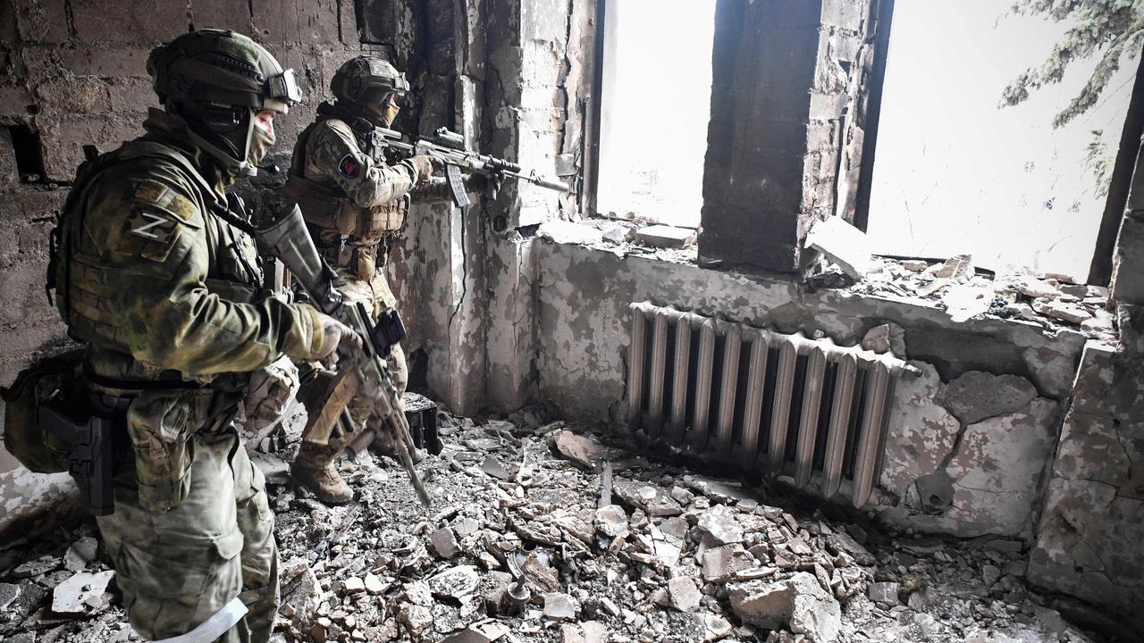 Two Russian soldiers patrol in the Mariupol drama theatre, bombed last March 16, in Mariupol. Picture: Alexander Nemenov / AFP