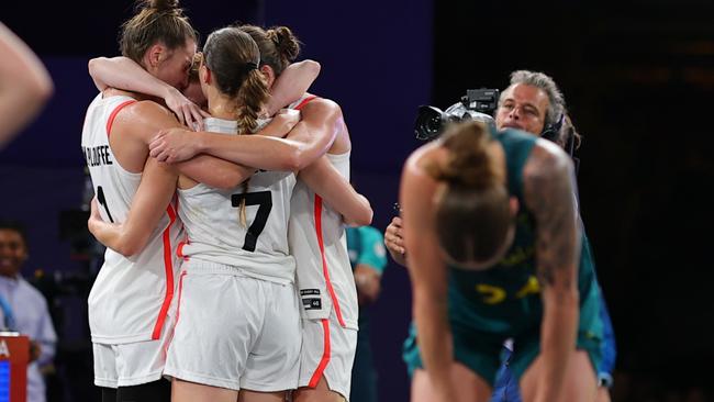 PARIS, FRANCE - AUGUST 03: Team Canada celebrate while Anneli Maley #24 of Team Australia reacts after Canada's victory during a Women's 3x3 basketball play-in game between Canada and Australia on day eight of the Olympic Games Paris 2024 at Esplanade Des Invalides on August 03, 2024 in Paris, France. (Photo by Buda Mendes/Getty Images)