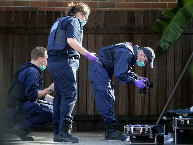 AFP forensic officers collecting evidence at a unitl complex in Punchbowl. Picture: Jonathan Ng