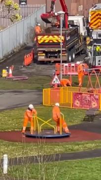 Tradies have a play break on a merry-go-round