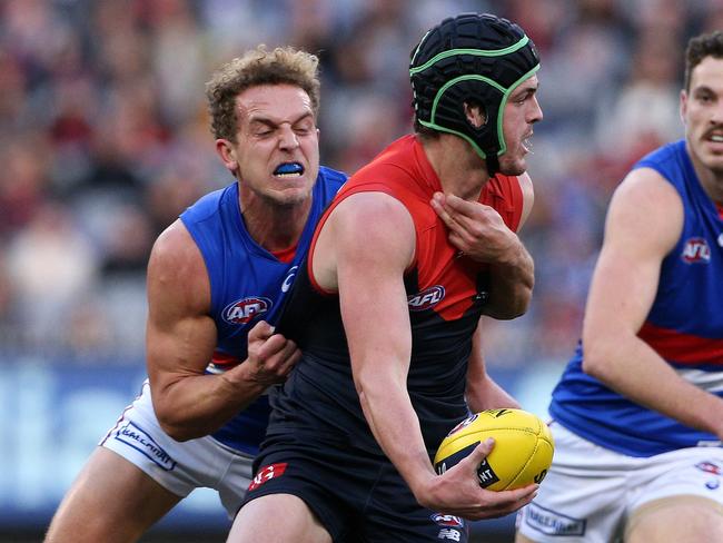 Angus Brayshaw of the Demons is tackled by Mitch Wallis of the Bulldogs during the Round 17 AFL match between the Melbourne Demons and the Western Bulldogs at the MCG in Melbourne, Saturday, July 14, 2018. (AAP Image/Hamish Blair) NO ARCHIVING, EDITORIAL USE ONLY