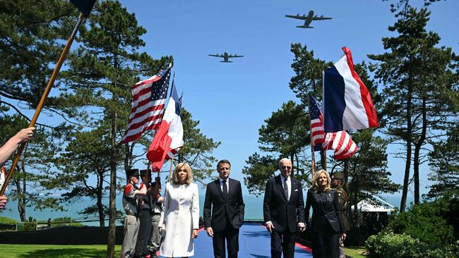 Douglas C-47 aircraft fly over as Joe Biden, Jill Biden, France's President Emmanuel Macron and his wife Brigitte walk past flag-bearers during the US ceremony marking the 80th anniversary of D-Day. Picture: AFP.