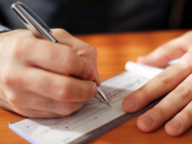 Generic photo of a person writing a cheque. Picture: iStock