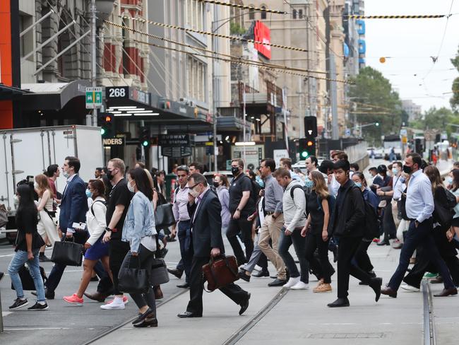 Many people returning to the city are opting to wear masks despite mandates being dropped. Picture: David Crosling