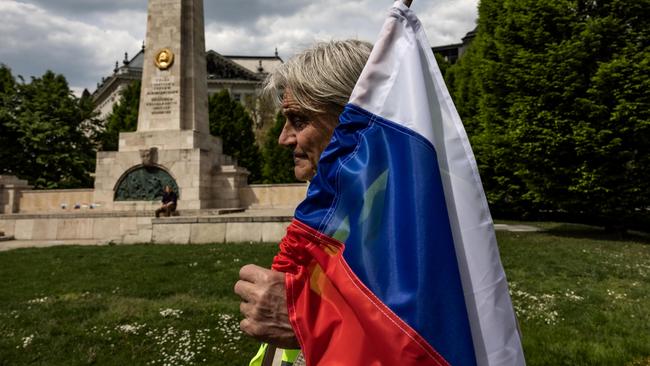 A pro-Putin demonstrator holds a Russian flag during a protest at Liberty Square in front of the Soviet Heroic Memorial in Budapest, Hungary.