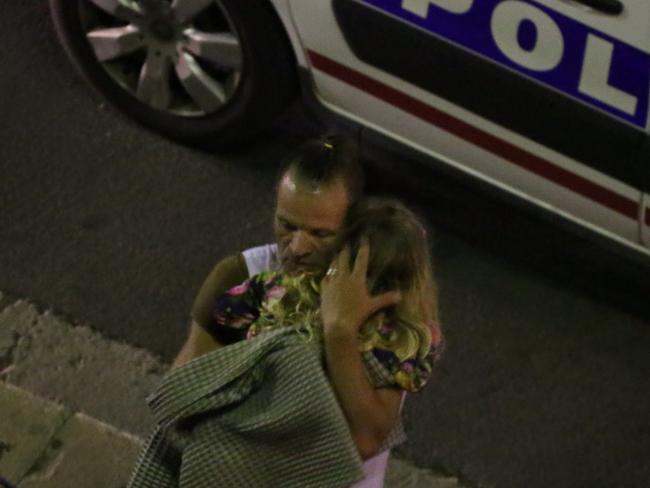 A man is seen holding a young girl after the attack. Picture: Sasha Goldsmith