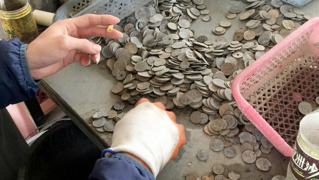 Damaged coins are pulled from piles of metal scrap. Picture: FormerFedsGroup.com