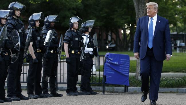 President Donald Trump walks past police in Lafayette Park after visiting outside St. John's Church across from the White House. Picture: AP Photo