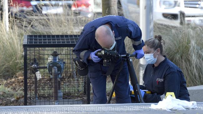 Forensic offices photograph evidence at the scene of the fatal Docklands stabbing. Picture: Andrew Henshaw