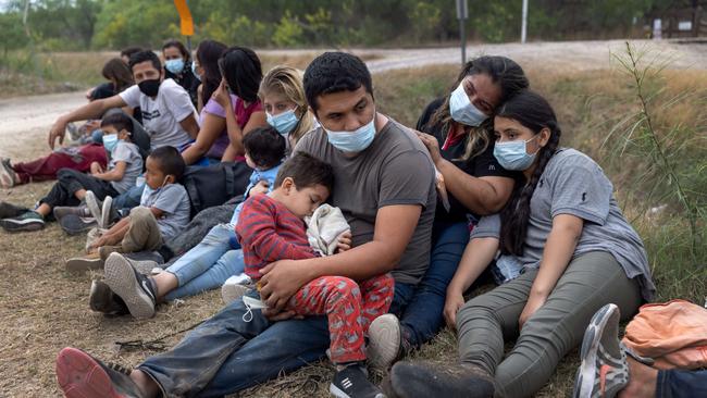 A Guatemalan family waits with fellow immigrants to board a US Customs and Border Protection bus to a processing centre after crossing the border from Mexico. Picture: AFP