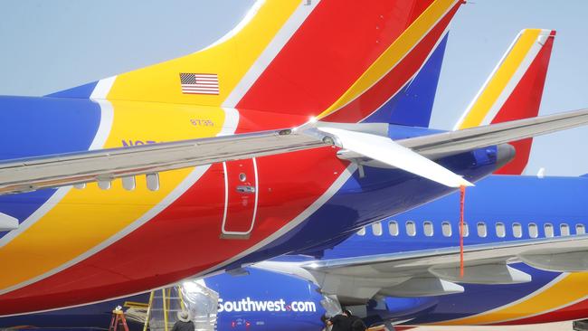 VICTORVILLE, CA - MARCH 27: Workers stand beneath Southwest Airlines Boeing 737 MAX aircraft parked at Southern California Logistics Airport on March 27, 2019 in Victorville, California. Southwest Airlines is waiting out a global grounding of MAX 8 and MAX 9 aircraft at the airport.   Mario Tama/Getty Images/AFP == FOR NEWSPAPERS, INTERNET, TELCOS & TELEVISION USE ONLY ==