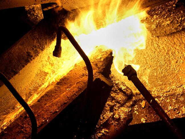 Molten steel passes through 'the flame' into the galvanizing pot at BlueScope Steel Ltd. works in Port Kembla, NSW. BLOOMBERG NEWS Pic Jack Atley