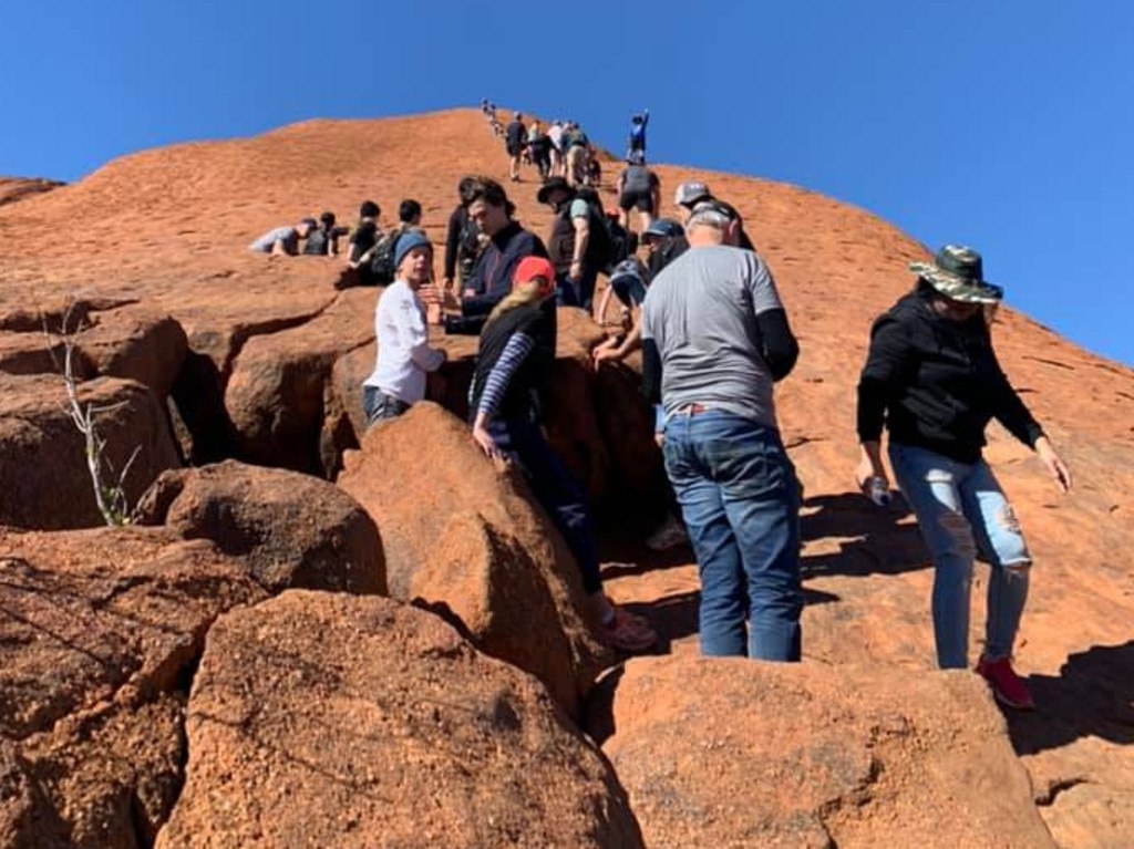 Tourists climbing Uluru.