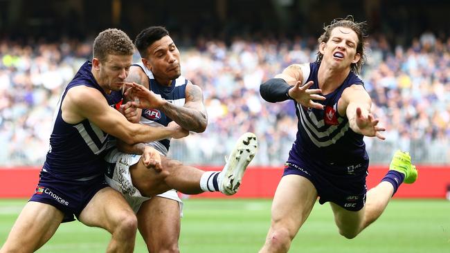 Nat Fyfe (right) tries to smother Cat Tim Kelly. Pic: AAP