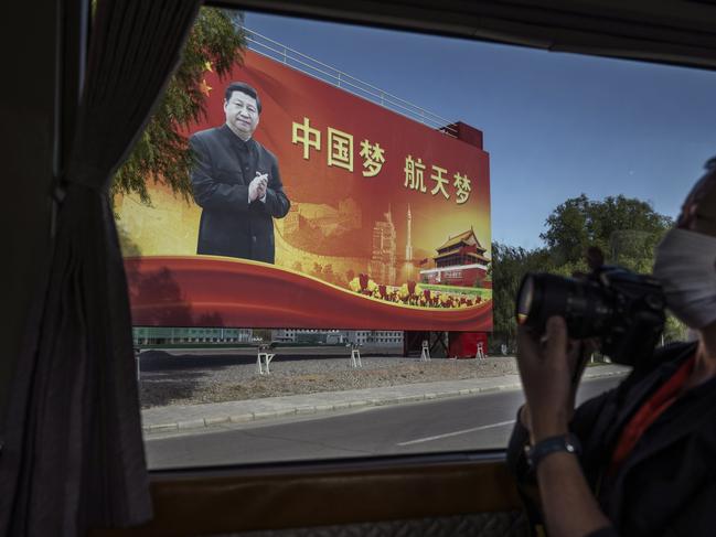 A billboard showing Chinese President Xi Jinping is seen as a bus carrying journalists arrives at the China Manned Space Agency before a pre-launch press conference overnight (AEST). Picture: Getty Images