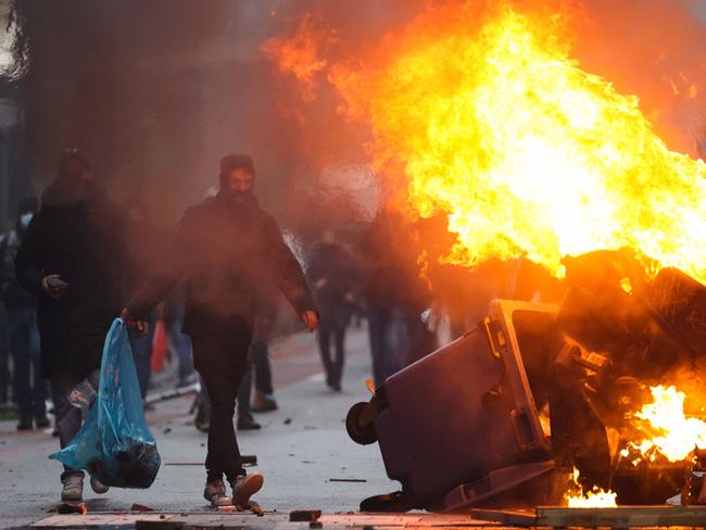 A man walks past burning rubbish as clashes erupt during a demonstration against Covid-19 measures in Brussels. Picture: AFP