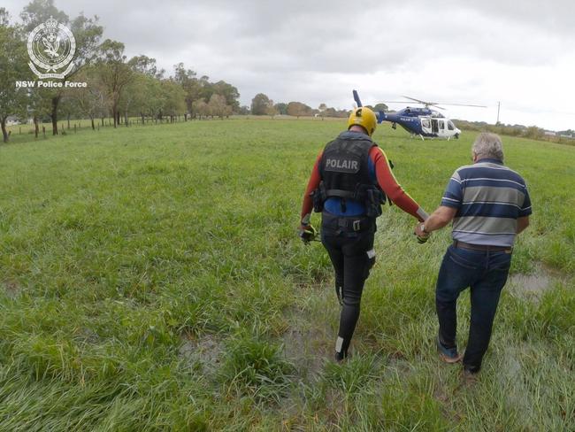 A resident is helped to a recovery centre near Taree, after being rescued by the NSW Police helicopter on 21 May.