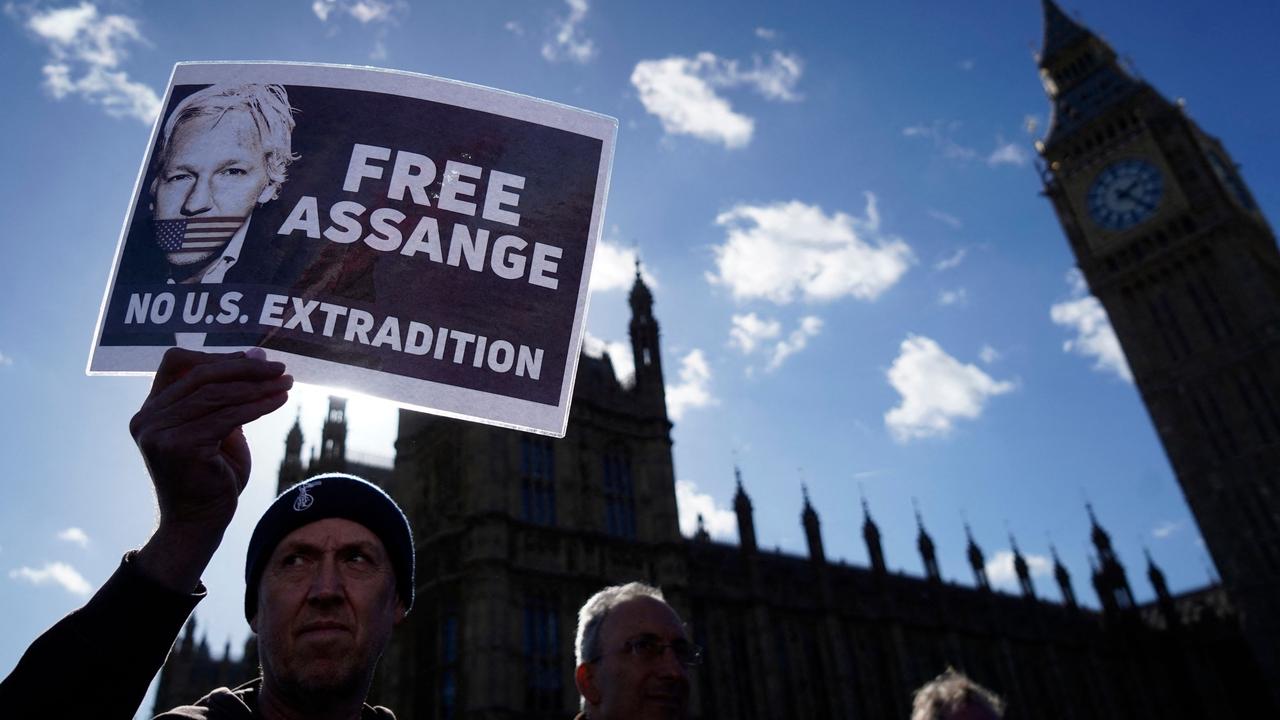 A supporter of WikiLeaks founder Julian Assange holds a placard outside of the Houses of Parliament, in London. Picture: AFP