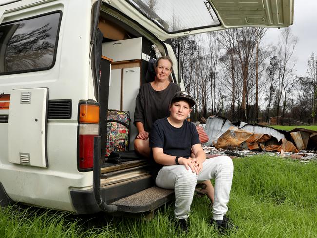 Kim Small with her son Mason in their campervan next to her husband Jon's home in Nerrigundah that was lost in the recent bushfires. Picture: Jonathan Ng
