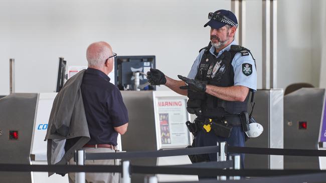 A policeman with a Qantas traveller at Adelaide Airport on Tuesday. Picture: Matt Loxton