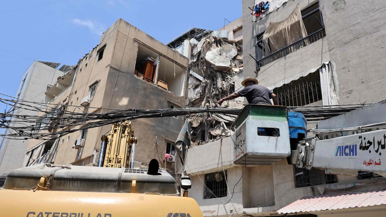 A worker clears debris one day after the Israeli military struck a building in Beirut's southern suburbs on July 31, 2024. (Photo by Anwar AMRO / AFP)