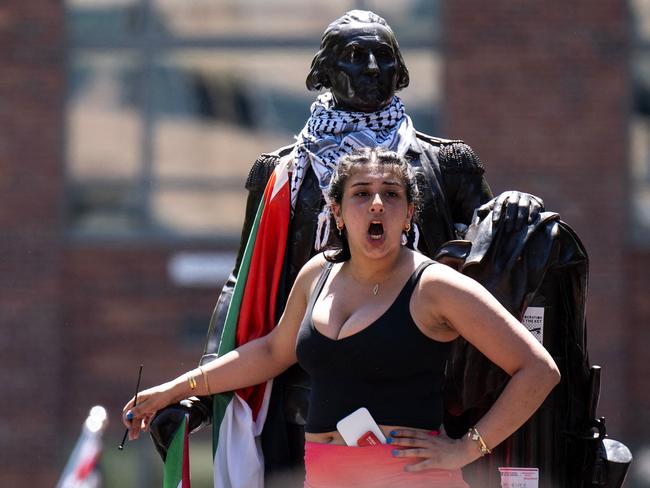 A pro-Palestinian student chants while standing on a statue of George Washington at George Washington University in Washington, DC. Picture: AFP