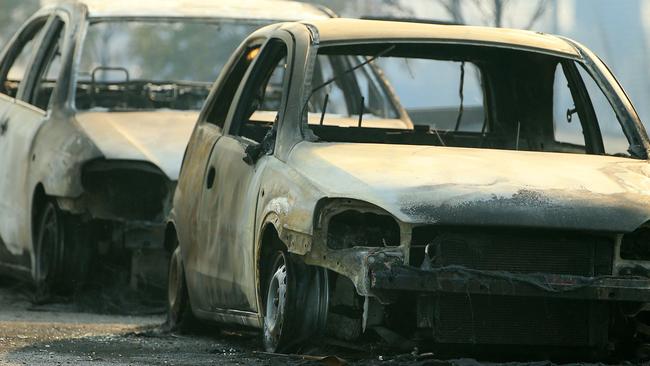 Burnt-out cars on the Frankston-Dandenong Rd after a bushfire blazed out of control. Picture: Mark Stewart