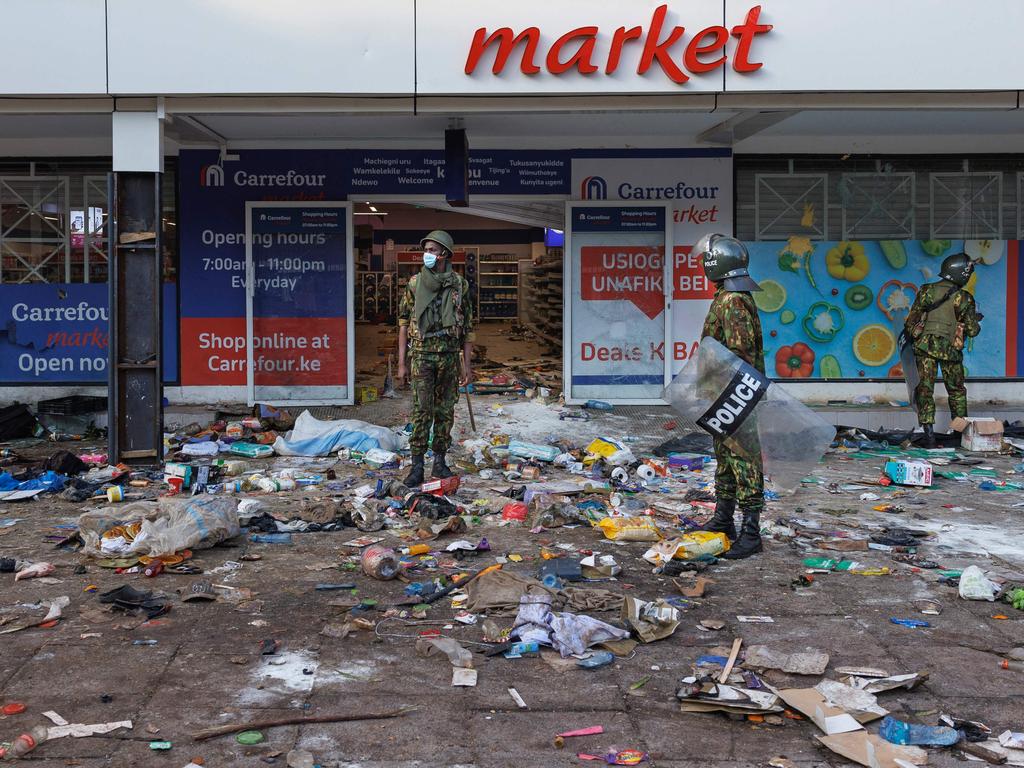 Riot police secure a supermarket that was looted and vandalised.