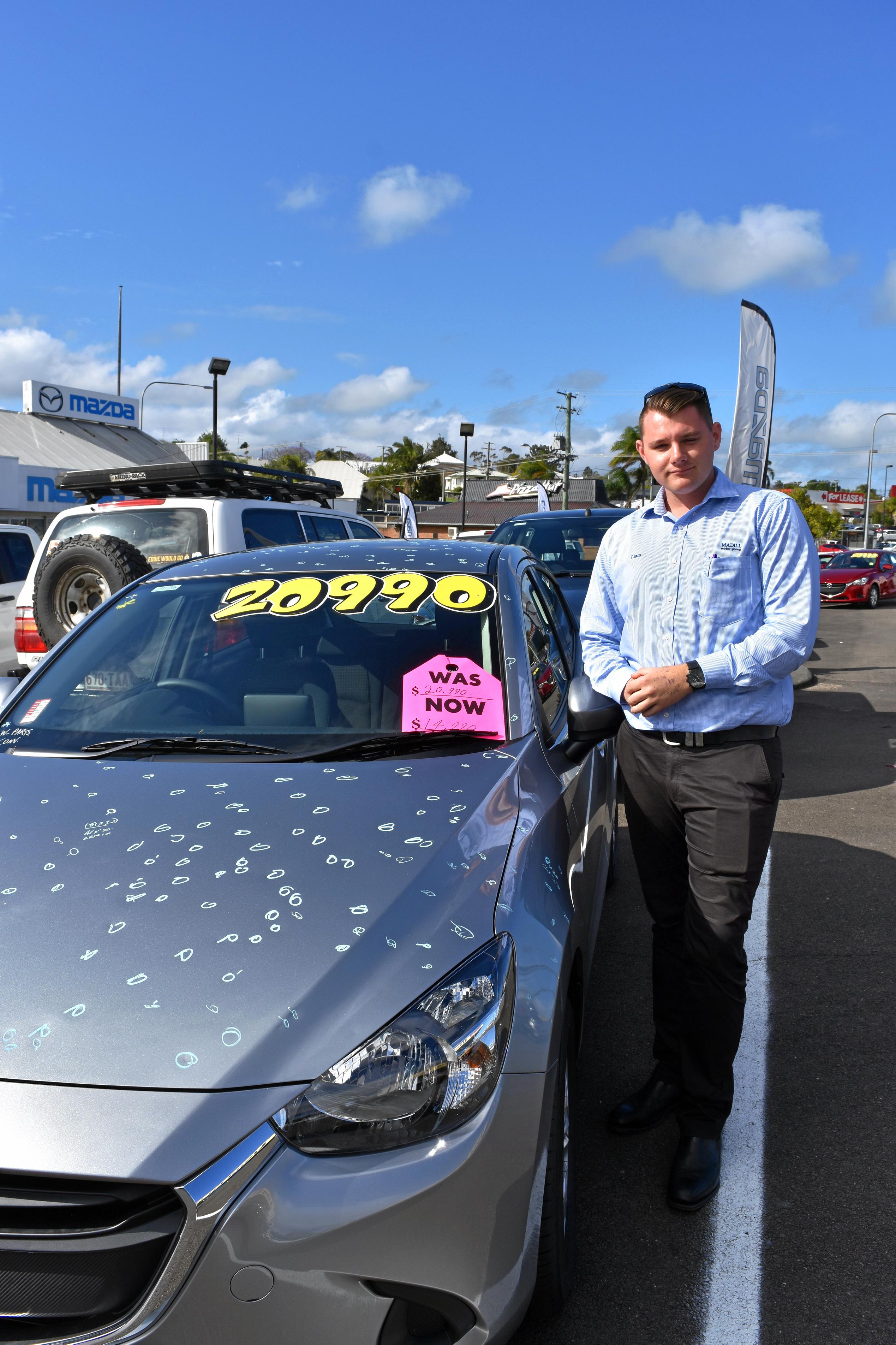 Liam Smith with one of the hail damaged cars at Madills Mazda. Picture: DONNA JONES