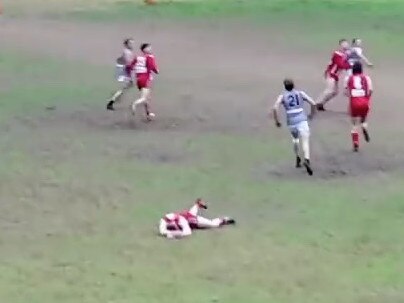 A Mount Lofty player lies motionless on the ground after being hit off the ball by a Hahndorf player. He was later hospitalised.