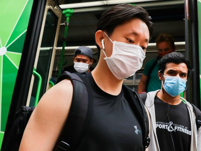 MELBOURNE, AUSTRALIA - FEBRUARY 04: People disembarking a tram are seen wearing masks on February 04, 2021 in Melbourne, Australia. Victoria has reintroduced COVID-19 restrictions after a hotel quarantine worker tested positive for coronavirus on Wednesday. The positive case was from one of the Australian Open quarantine hotels, with some 600 Australian Open players, officials and support staff told to isolate and get tested. All tennis matches at Melbourne Park on Thursday have been called off. Masks are now mandatory indoors across Victoria with gatherings now limited to 15 people in a household while the 75 percent return to work plan, scheduled to begin on Monda has been paused. (Photo by Asanka Ratnayake/Getty Images)