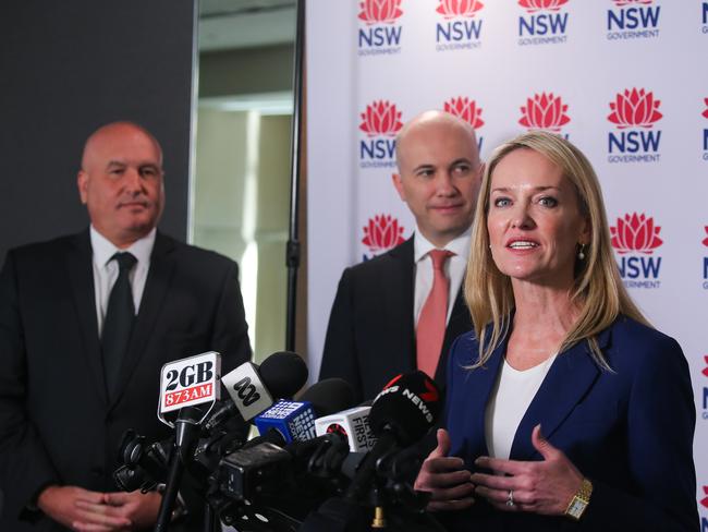 Minister for Transport David Elliott watches on with Treasurer Matt Kean, as Minister for Roads Natalie Ward addresses the media during a press conference.