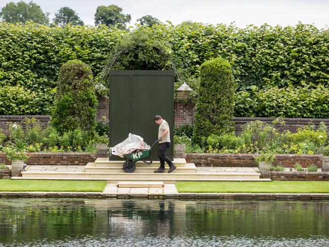 Gardeners work around the covered statue in the Sunken Garden at Kensington Palace in London. Picture: Getty Images