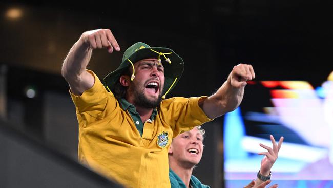 Australian fans cheer in the stands during the marathon match. (Photo by WILLIAM WEST / AFP)