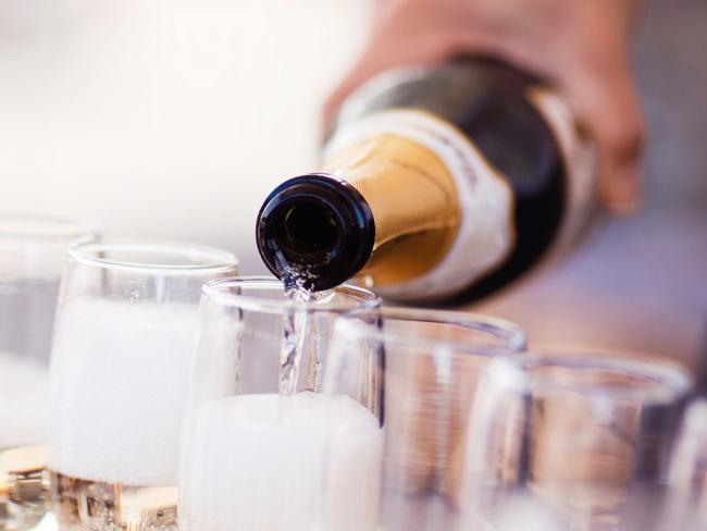 Waiter serving a glass of sparkling white wine