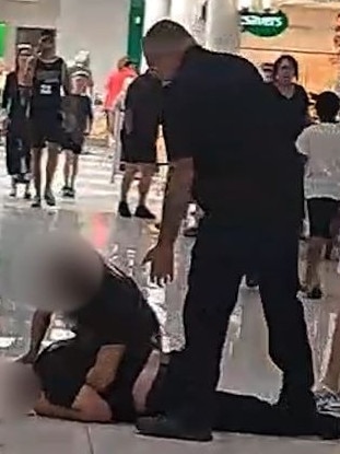 A security guard attempts to break up the brawling men.