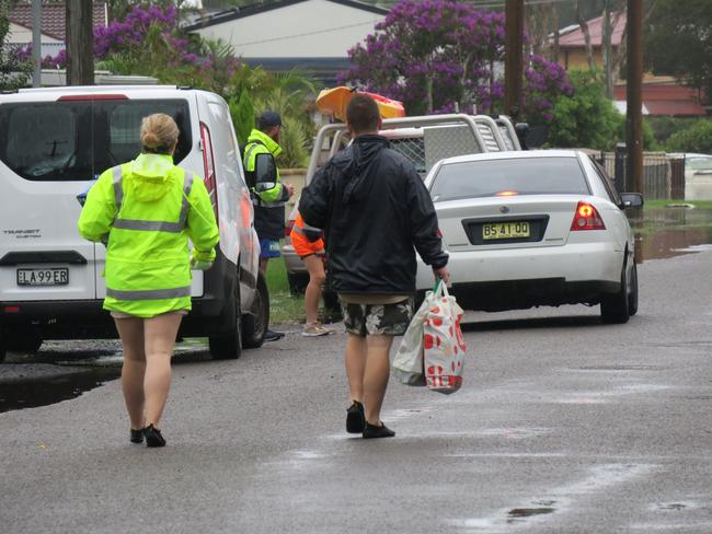 Residents of Geoffrey Rd, Chittaway Point, have to park their cars up the road before wading through flood water to get to their homes. Picture: Richard Noone