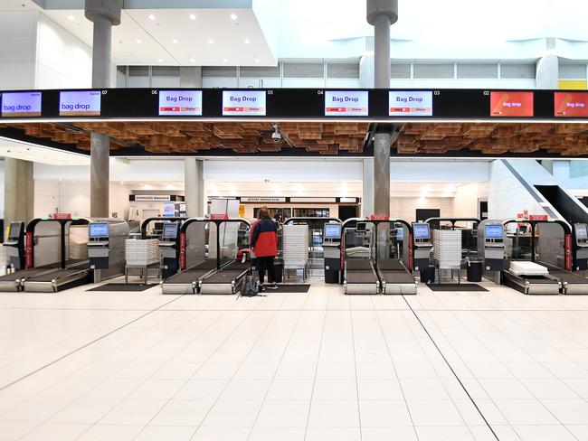 A lone passenger is seen using the self check-in at the Jetstar terminal at Brisbane Airport. Travel bans are keeping the COVID-19 spread down in Australia. Picture: AAP