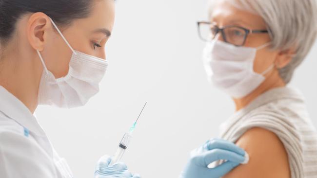 Doctor giving a senior woman a vaccination