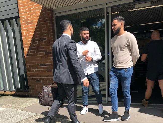 Malik Mohammad, centre in white shirt, leaves Waverley Local Court in the company of his supporters