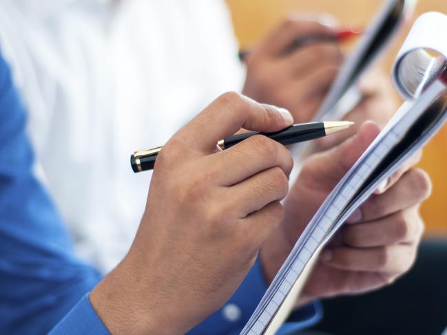 Business people writing on notepad. Generic shot of reporter. Picture: ThinkStock