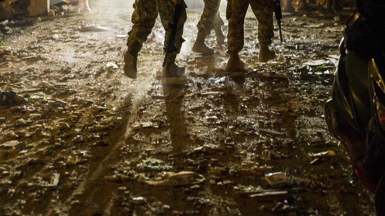 Soldiers walk through a street littered in debris. Picture: Getty Images