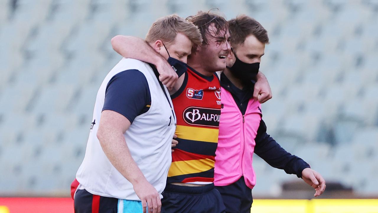 Luke Pedlar is helped off the field by trainers in a 2021 SANFL game. (SANFL Image/David Mariuz)