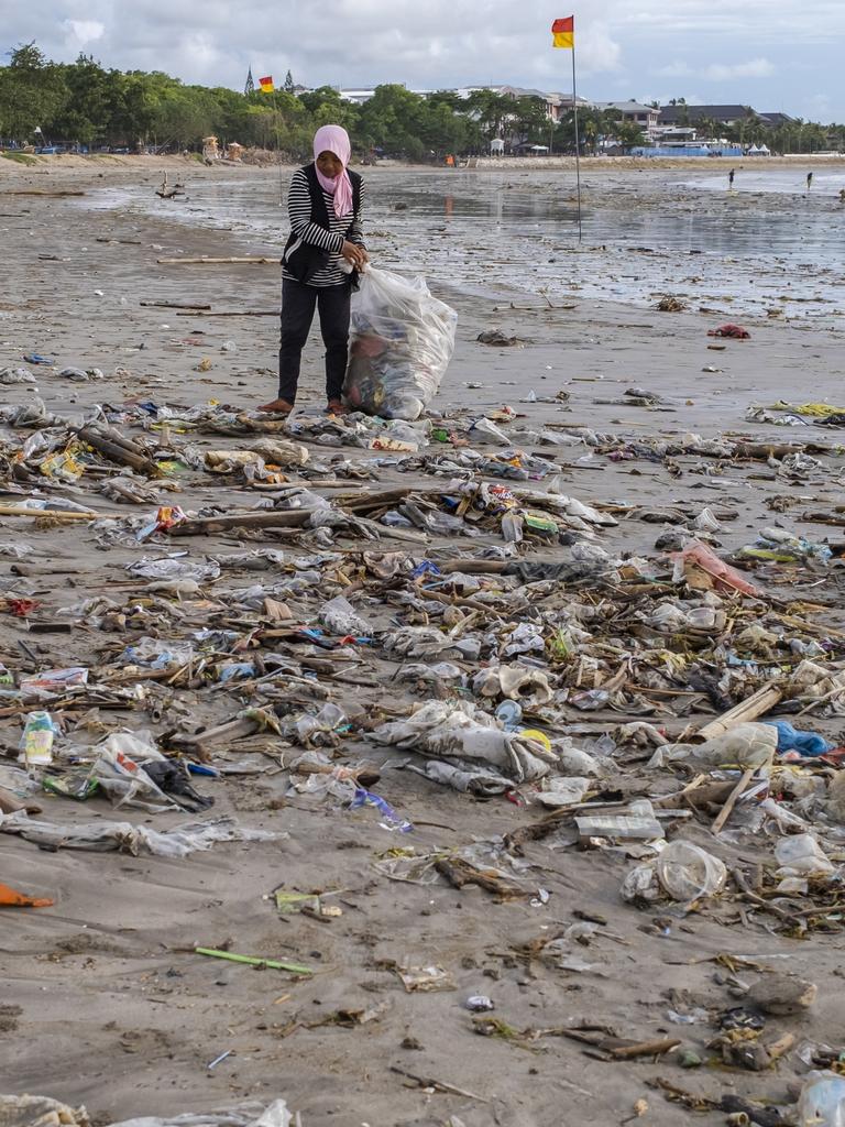 A woman seen collecting the waste. Picture: Made Nagi/EPA/AAP