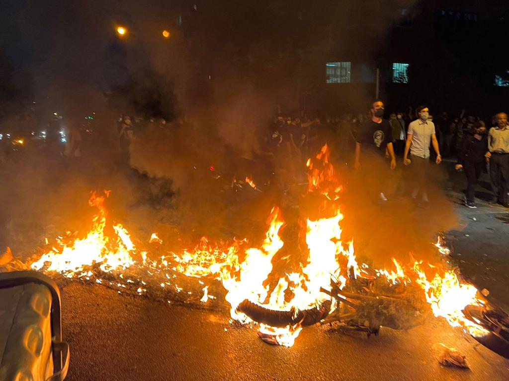 Demonstrators gather near a motorbike on fire during a protest for Mahsa Amini. Picture: AFP