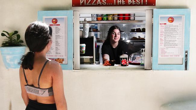 Staff member Amber Rankin serves a customer at a new hole-in-the-wall takeaway cafe at Tallebudgera Creek. Picture: Glenn Hampson