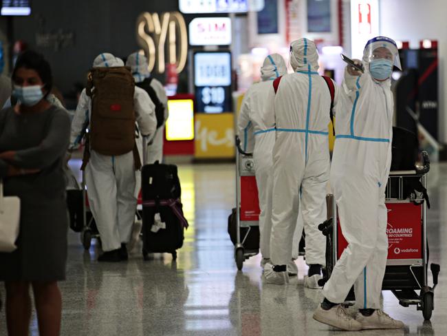 People in full PPE arriving at Sydney International Airport. Picture: Adam Yip